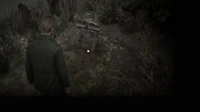 Silent Hill 2 – Capture d'écran montrant James Sunderland qui trouve le livre Cérémonie écarlate près d'une tombe