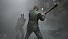 《Silent Hill 2》螢幕截圖，顯示詹姆斯朝怪物揮動武器