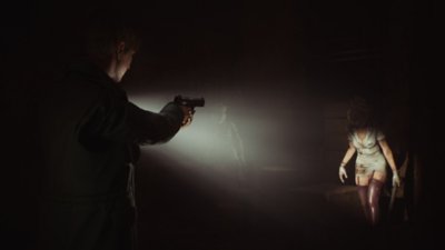 Silent Hill 2 ภาพหน้าจอแสดงให้เห็น James ส่องไฟฉายไปที่หุ่นแสดงแบบเสื้อ 