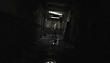 Screenshot van Silent Hill 2 met een monster dat aan het einde van een gang staat