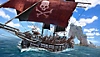 Skull & Bones ekran görüntüsü, kırmızı ana yelkeni üzerinde kafatası ve çapraz kemiklerin olduğu bir korsan gemisini gösteriyor