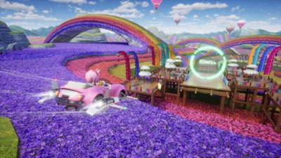 Sonic Racing: CrossWorlds – Capture d'écran montrant Amy dérapant avec son véhicule sur un circuit fait de fleurs colorées, en direction de la suite du parcours