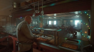 Captura de pantalla de Still Wakes the Deep que muestra miembros de la tripulación y un cocinero en la cocina y comedor de la plataforma petrolera