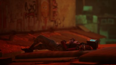 《Stray》螢幕截圖，呈現貓主角縮著身體陪伴機器人躺在地上熟睡