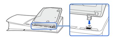 Vista lateral de una consola PS5 con la cubierta con el círculo retirada y la unidad de disco insertada.