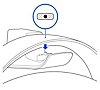 Detail nasazování sluchátek s mikrofonem na nabíjecí háček. Popisek zobrazuje konektory na háčku, které se zasouvají do nabíjecích koncovek uprostřed náhlavního oblouku.