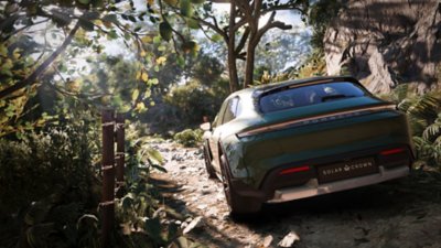 Test Drive Unlimited Solar Crown screenshot showing a Porsche driving through a wooded area