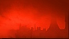 Hintergrundbild von The Ascent – eine Stadtsilhouette unter einem roten Himmel