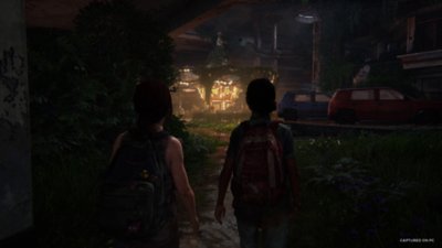 The Last of Us Part I screenshot showing a scene from Left Behind, where Ellie and Riley are walking towards a disused merry-go-round