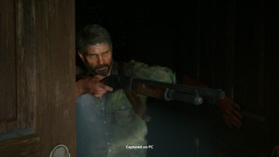 The Last of Us Part II Remastered for PC screenshot showing Joel aiming his shotgun at an unseen target