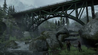 Imagen que muestra una captura de pantalla de The Last of Us: Remastered con Joel y Ellie frente a un puente desolado