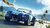 The Crew Motorfest screenshot showing a Shelby Cobra racing on a palm tree-lined road.
