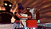 لقطة شاشة من لعبة Thirsty Suitors تعرض Jala وهي تطهي الطعام في وعاء على موقد يعمل بالغار بينما تراقبها شخصيات ضخمة غير واضحة المعالم.