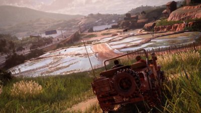 لقطة شاشة من Uncharted 4 تعرض "ناثان" و"سام" يقودان سيارة jeep باتجاه مزرعة