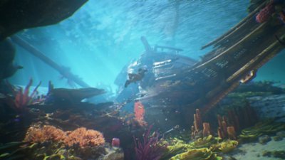 لقطة شاشة من Uncharted 4 تعرض "ناثان" يسبح تحت الماء في حطام سفينة مغطاة بالشعب المرجانية والنباتات البحرية الأخرى