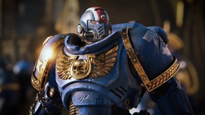 Warhammer 40,000: Space Marine 2 – snímka obrazovky zobrazujúca v detailnom zábere mariňáka v modrej zbroji so zlatým erbom na hrudi