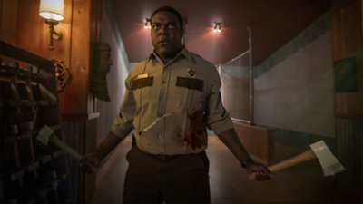 Finn Wheeler (Sam Richardson) die twee bijlen vasthoudt.