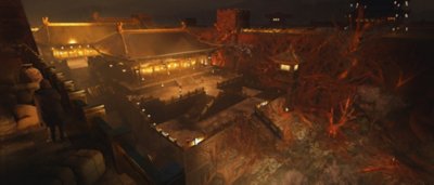 ภาพหน้าจอ Wo Long Fallen Dynasty แสดงให้เห็นสิ่งก่อสร้างอยู่หลังกำแพงปราสาทโดยมีแสงจากโคมไฟ