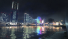 ترى ظلال مدينة يوكوهاما على الماء ليلاً. تظهر عجلة دوارة بألوان قوس قزح إلى جانب العديد من ناطحات السحاب